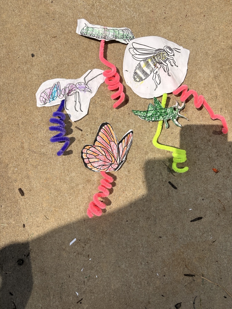 Paper pollinator crafts made by kids: bee, butterfly, ant, caterpillar and grasshopper on pipe cleaners